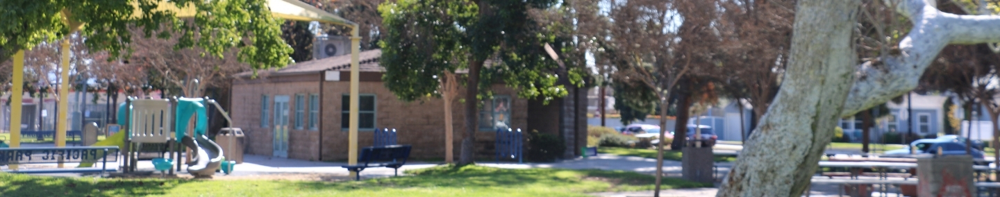 A photo of Johnny Carson Park playground, shade structure, and children playing.