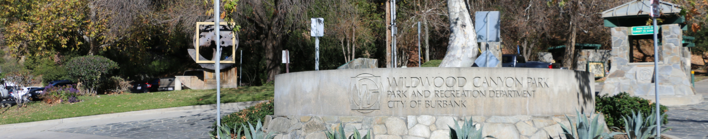 A photo of Johnny Carson Park playground, shade structure, and children playing.