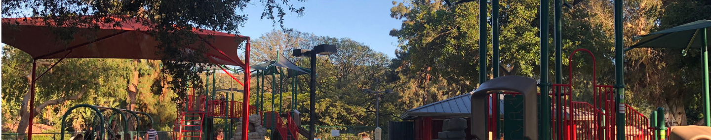 A photo of Johnny Carson Park playground, shade structure, and children playing.